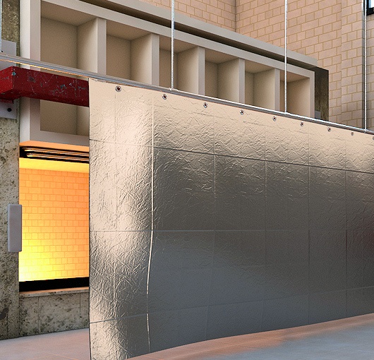 Industrial heat shield curtain installed to block radiant heat in a workshop, heavy-gauge fabric providing thermal protection for personnel and equipment