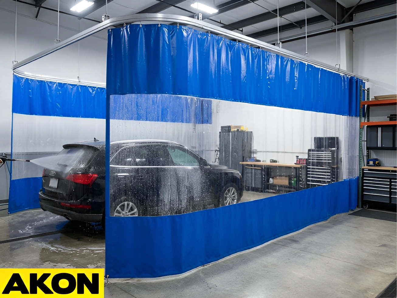 AKON blue garage wash bay curtains with clear vision panels creating a vehicle washing enclosure inside an indoor garage