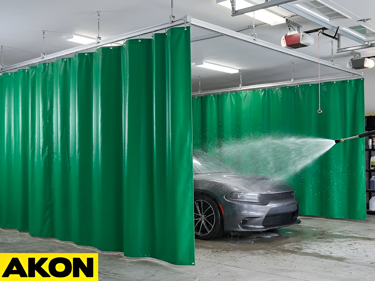AKON green garage wash bay curtains containing water spray while a car is pressure washed inside a garage wash bay enclosure