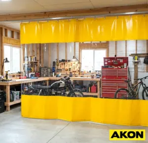 A heavy-duty curtain divider installed in a garage to separate work zones or block off a section of the space.