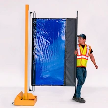Retractable welding curtain screen deployed in factory workspace for separating welding zones