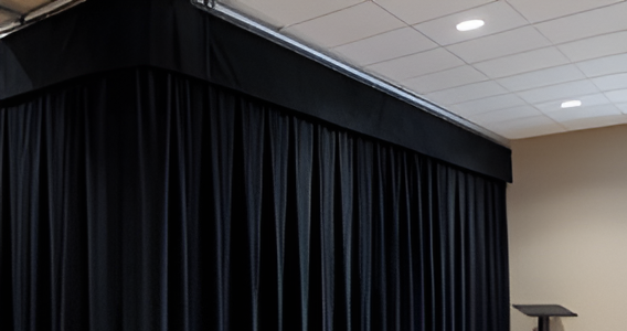 Black church divider curtain with valance installed above stage area