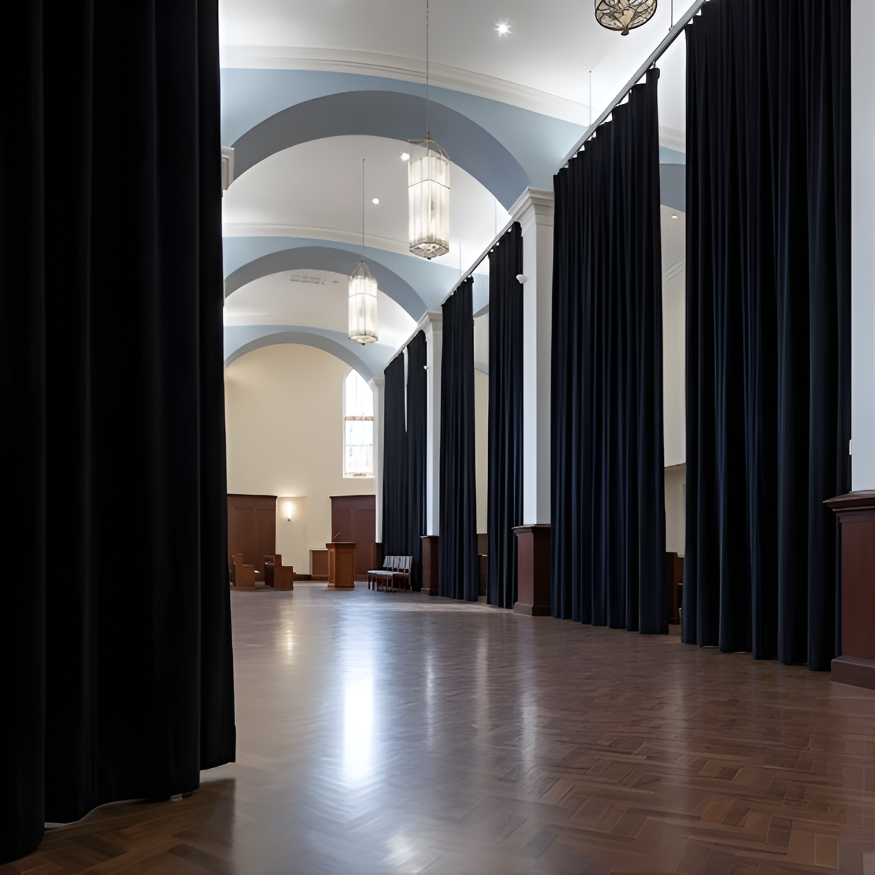 Black church divider curtains installed between columns in a worship facility