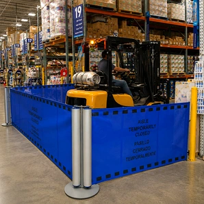 Portable barriers set up in an industrial facility to divide or restrict access to a work area.