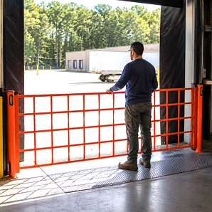 Retractable dock barrier stretched across a loading dock opening to block access and contain temperature or debris.