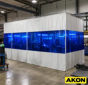 Welding safety curtains hanging in an industrial workspace to shield nearby workers from arc flash and UV radiation.